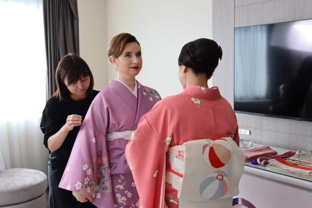 Licensed kimono stylist dressing a guest in a Tokyo hotel room